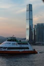 Vertical shot of a sailing boat with beautiful buildings in the background taken in Hong Kong