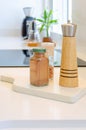 Vertical shot of a salt grinder and glass bottles of spices on a kitchen table Royalty Free Stock Photo