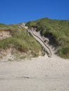Vertical shot of a sandy hill with wooden stairs Royalty Free Stock Photo