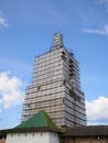 Scaffolding from planks around old bell tower. Background blue sky with clouds. Royalty Free Stock Photo