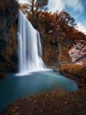 Vertical shot of a scenic waterfall and autumnal plants