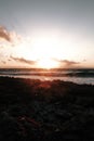 Vertical shot of the sea and a rocky beach on a cloudy sunny day Royalty Free Stock Photo