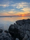 Vertical shot of the sea at sunset with a boat silhouette in the background Royalty Free Stock Photo