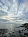 Vertical shot of the sea surrounded by rocks under a cloudy sky on a gloomy day Royalty Free Stock Photo