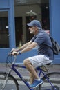 Vertical shot of a senior male riding a bicycle in the streets of Paris