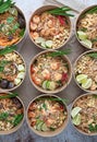 Vertical shot of servings of delicious noodles with salads, lime, greens, seafood, and crumbs