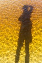 Vertical shot of a shadow of a person dropping on the Guaibimzinho river