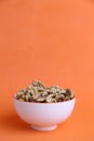 Vertical shot of shelled walnut bowl on orange background Royalty Free Stock Photo