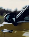 Vertical shot of the side mirror of a Volkswagen Arteon gold color