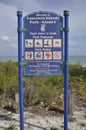 Vertical shot of a sign in front of a beach in Sanibel Island, Miami, USA