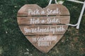 Vertical shot of signage, pick a seat either side on a wedding day with a blurred background.