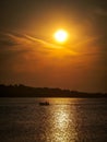 Vertical shot of a silhouette of a boat in the sea in the sunset Royalty Free Stock Photo