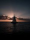 Vertical shot of a silhouette of a boat in the sea in sunset Royalty Free Stock Photo