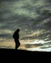 Vertical shot of a silhouette of a lonely person walking at sunset