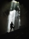 Vertical shot of a silhouette of a man inside a cave Royalty Free Stock Photo