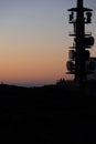 Vertical shot of a silhouette of a telecommunication mast at sunset.