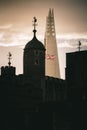 Vertical shot of the silhouette of the Tower of London with the flag of the UK r in London, UK