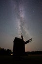 Vertical shot of the silhouette of a windmill under the Milky Way constellation at night