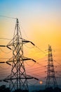 Vertical shot of the silhouettes of electricity poles under a sunset sky in Haryana, India