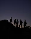 Vertical shot of silhouettes of people standing on a hill under the beautiful night sky Royalty Free Stock Photo