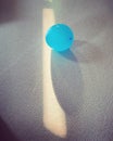 Vertical shot of single blue balloon on the carpet with reflection of sunlight Royalty Free Stock Photo