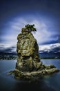 Vertical shot of Siwash Rock in Vancouver BC in Stanley Park under the beautiful cloudy sky Royalty Free Stock Photo