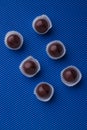 Vertical shot six chocolate candies on blue background. Royalty Free Stock Photo