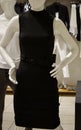 Vertical shot of a sleeveless black dress with a belt on a mannequin at a store