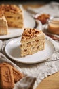 Vertical shot of a slice of delicious lotus cookie cake with caramel with cookies on the table