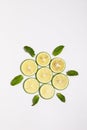 Vertical shot of slices of lime and mint leaves on a white surface Royalty Free Stock Photo