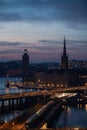 Vertical shot of Slussen surrounded by buildings and lights in the evening in Stockholm, Sweden