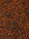 Vertical shot of small black and orange grains of sand for backgrounds