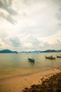 Vertical shot of small boats in the sea next to the shore on a cloudy day Royalty Free Stock Photo