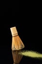 Vertical shot of a small broom sweeping the yellow dust on black background