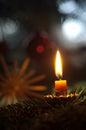 Vertical shot of a small candle burning in the dark with a blurry background Royalty Free Stock Photo