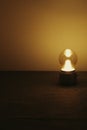 Vertical shot of a small lamp on a wooden table, artsy aesthetic