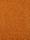 Vertical shot of small orange grains of sand for backgrounds