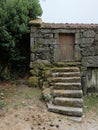 Vertical shot of a small stone construction with a staircase covered with moss Royalty Free Stock Photo