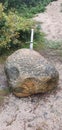 Vertical shot of a small sword in the stone on a sunny day