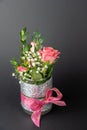 Vertical shot of a small vase with a pink bow and rose flowers Royalty Free Stock Photo