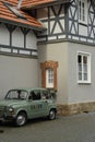 Vertical shot of a small vintage green FIAT 500 near a mining lorry in Goslar, Germany