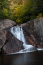 Vertical shot of a small waterfall flowing over the rocks Royalty Free Stock Photo
