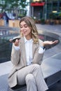 Vertical shot of smiling office lady in suit leaving voice message, talking into speaker on mobile phone, translating Royalty Free Stock Photo