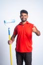 Vertical shot of smiling painter with paint roller brush showing thumbs up sign by looking camera - concept of