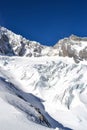 Vertical shot of snowy sharp mountains under a blue sky