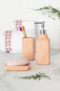 Vertical shot of soap, soap dispenser, tumbler, toothbrush, and towel in the bathroom Royalty Free Stock Photo