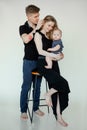 Vertical shot of solicitous happy spouses, barefoot family, man, woman, child on bar chair. Caring and loving concept