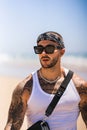 Vertical shot of the Spanish, young man with tattoos at the beach Royalty Free Stock Photo