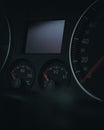 Vertical shot of the speedometer and tachometer of a car on the black background