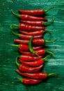 Vertical shot of spicy fresh chilis on a green background Royalty Free Stock Photo